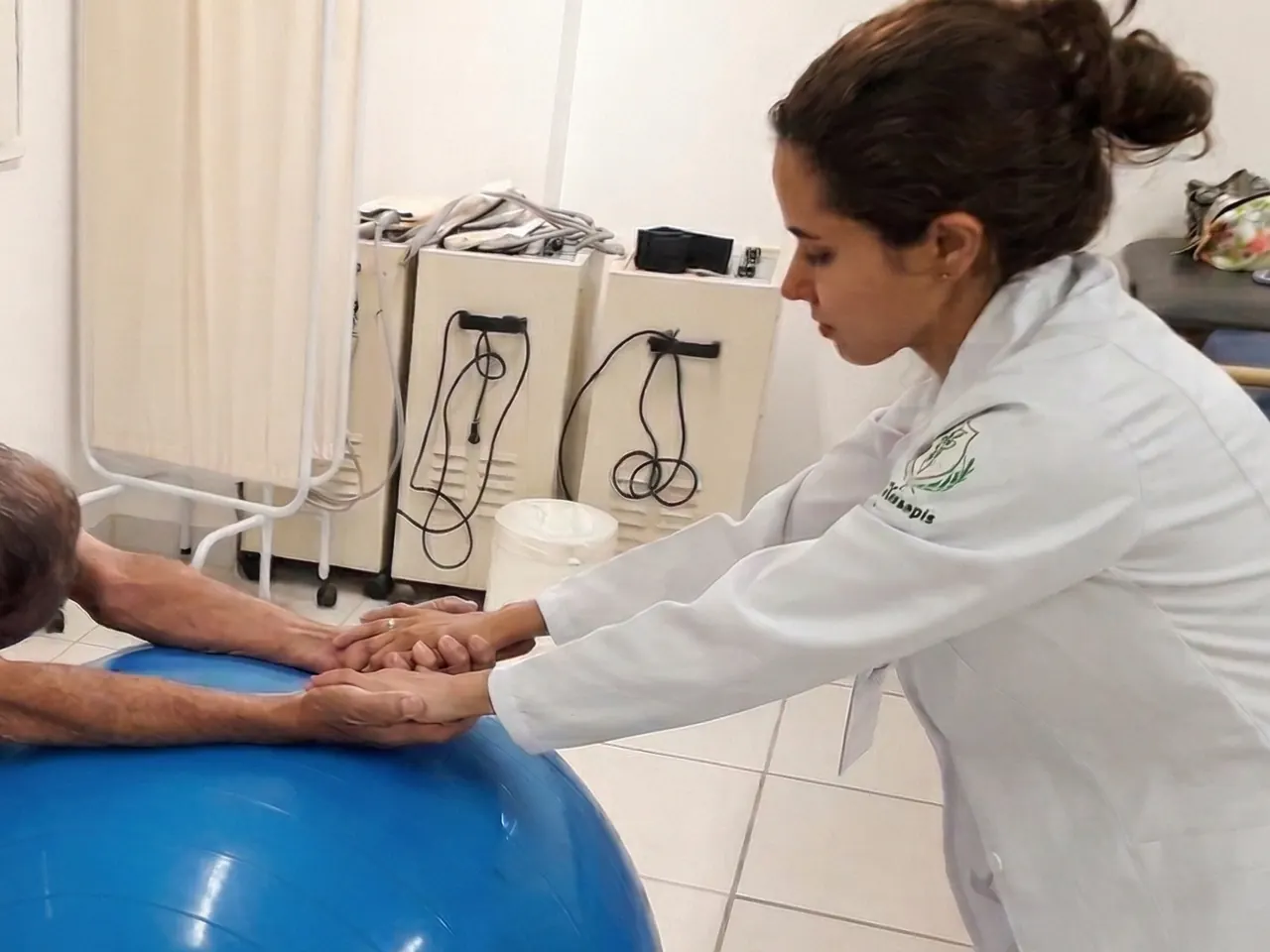 Dra. Regiane acompanhando um paciente durante um exercício fisioterapêutico